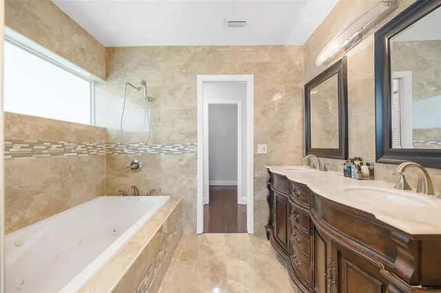 a spacious bathroom with a bathtub sink and mirror