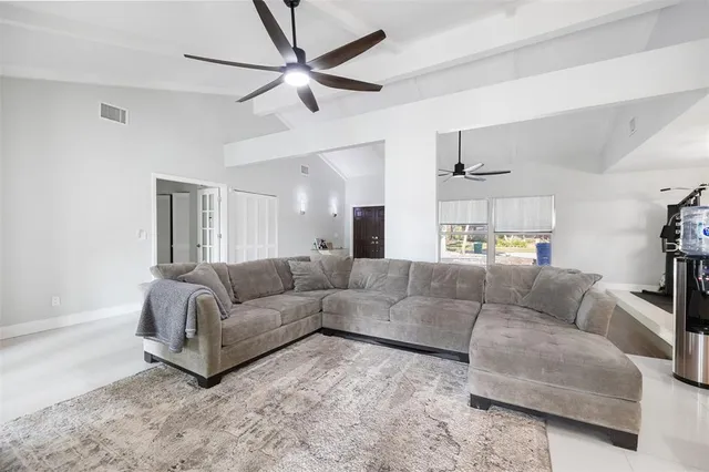 a living room with furniture and a ceiling fan