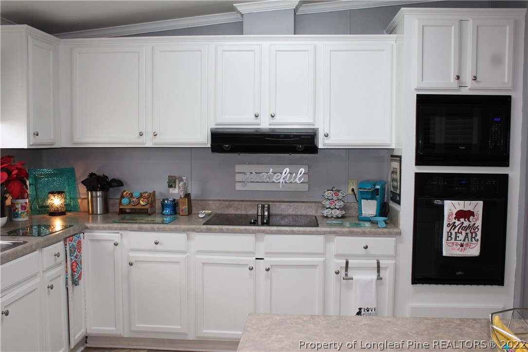 6520 Faircloth Bridge Road Stedman, NC 28391 - Photo 7 of 39 a kitchen with white cabinets and sink