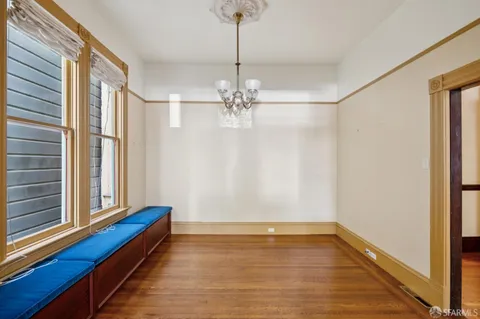 a view of a hallway with wooden floor and a chandelier