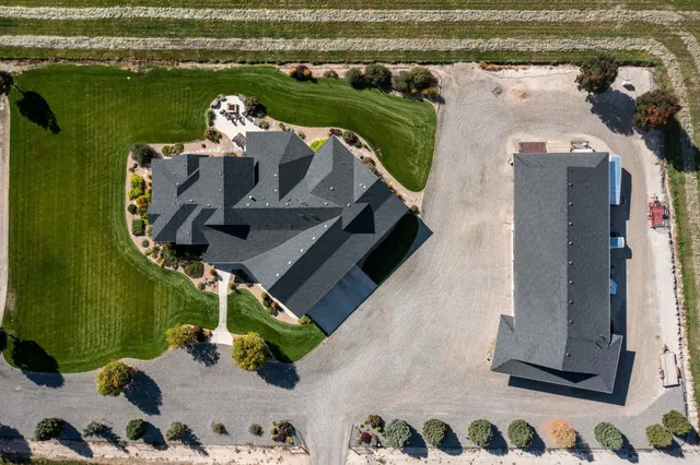 a front view of a house with a garden and trees