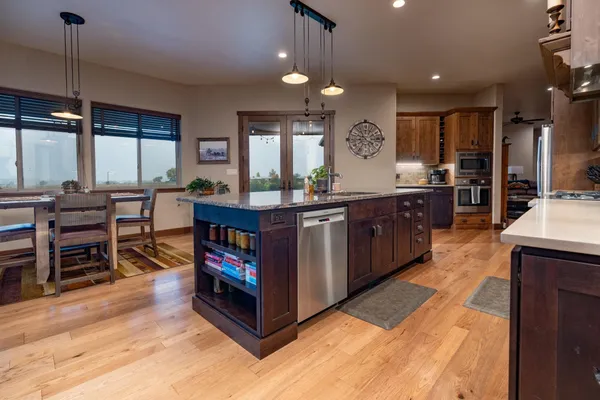 a kitchen with stainless steel appliances kitchen island granite countertop a table and chairs in it