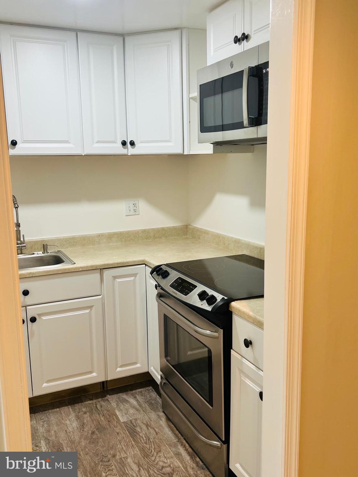 13249 # Lane Silver Spring, MD 20904 - Photo 10 of 34 a kitchen with granite countertop cabinets stainless steel appliances and wooden floor