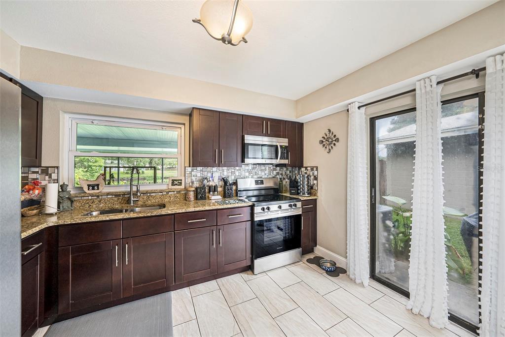 4805 Grove Point Drive Tampa, FL 33624 - Photo 11 of 35 a kitchen with stainless steel appliances granite countertop a stove sink and cabinets