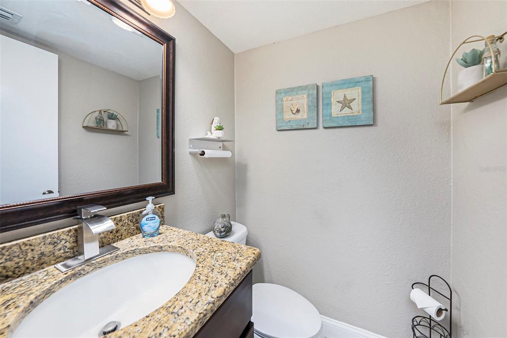4805 Grove Point Drive Tampa, FL 33624 - Photo 13 of 35 a bathroom with a granite countertop toilet a sink and mirror
