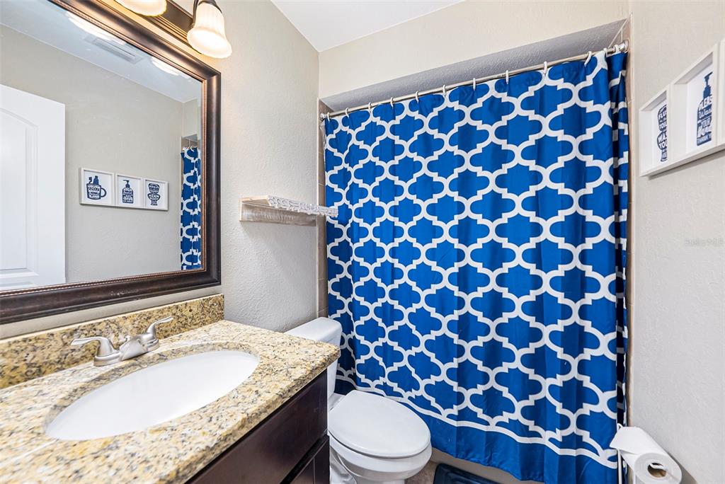 4805 Grove Point Drive Tampa, FL 33624 - Photo 19 of 35 a bathroom with a granite countertop toilet and a sink