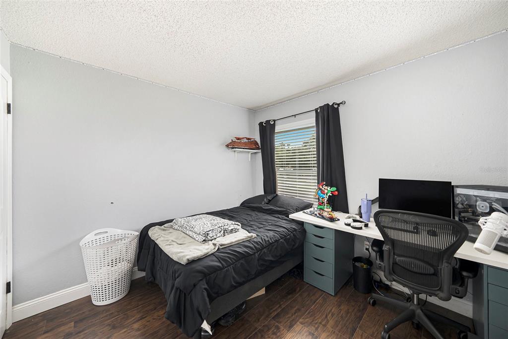 4805 Grove Point Drive Tampa, FL 33624 - Photo 21 of 35 a bedroom with a bed and a computer on a table