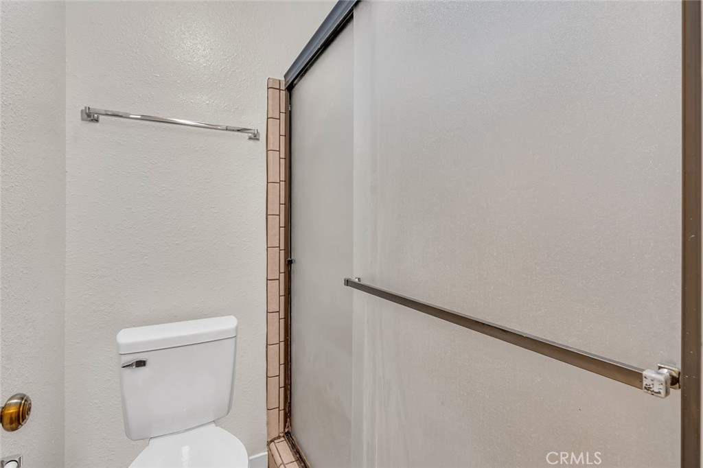 3350-74 M Street Merced, CA 95348 - Photo 18 of 55 a white toilet sitting next to a shower curtain
