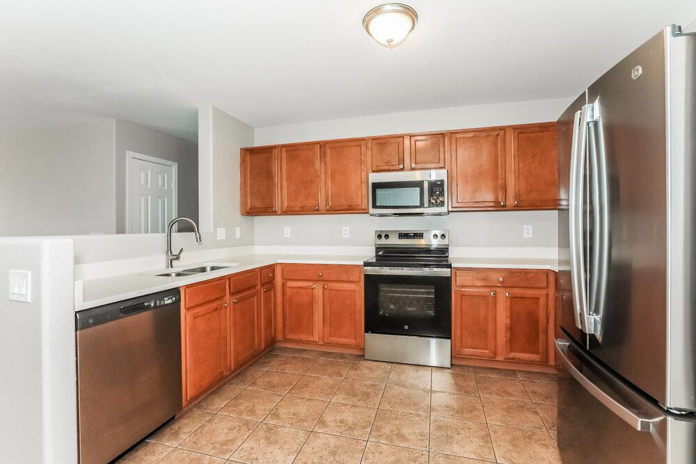 30559 North Nightingale Road San Tan Valley, AZ 85143 - Photo 8 of 16 a kitchen with stainless steel appliances granite countertop a refrigerator stove and sink