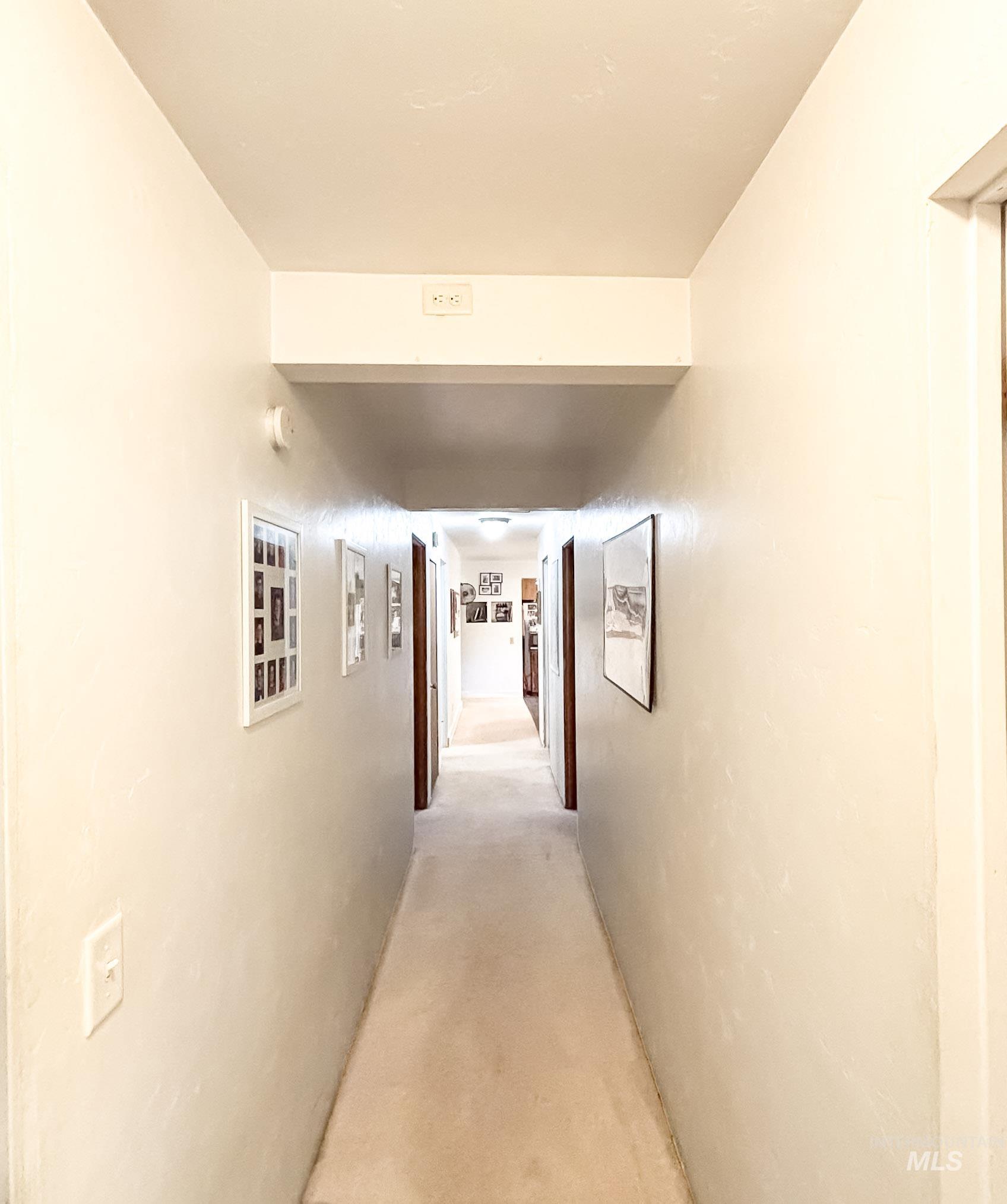 1650 Wells Bench Road Orofino, ID 83544 - Photo 17 of 44 Carpeted hallway with light-toned walls and multiple doorways