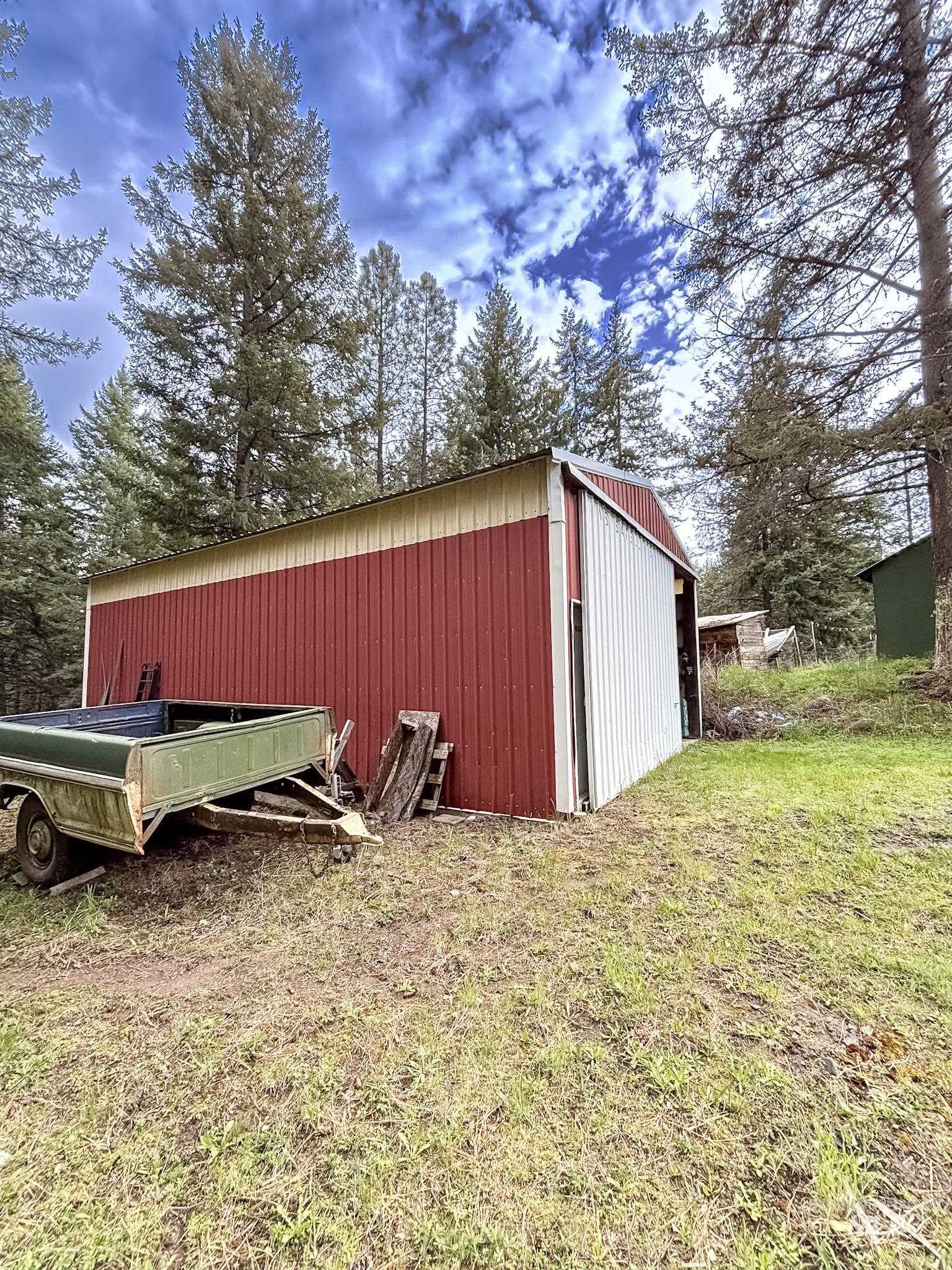 1650 Wells Bench Road Orofino, ID 83544 - Photo 30 of 44 Red and beige metal workshop building with a tall white overhead door