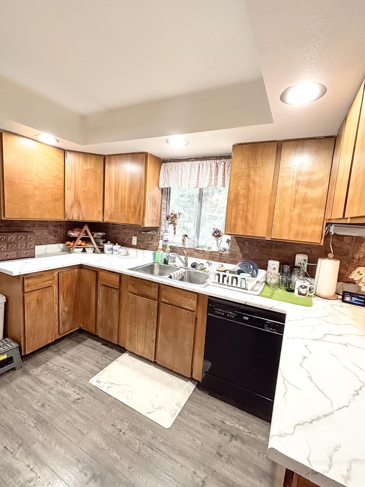 1650 Wells Bench Road Orofino, ID 83544 - Photo 9 of 44 Kitchen featuring wood-finish cabinetry, white countertops with gray veining, double basin stainless steel sink, black dishwasher, and recessed ceiling lighting