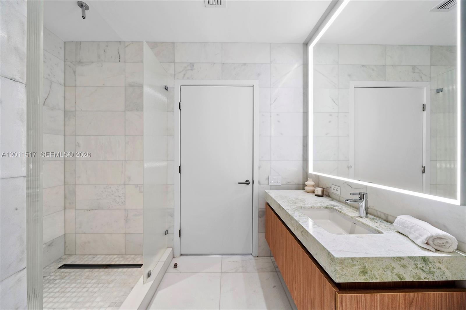 500 Alton Road, Unit 501 Miami Beach, FL 33139 - Photo 13 of 14 a bathroom with a granite countertop double vanity sink and shower