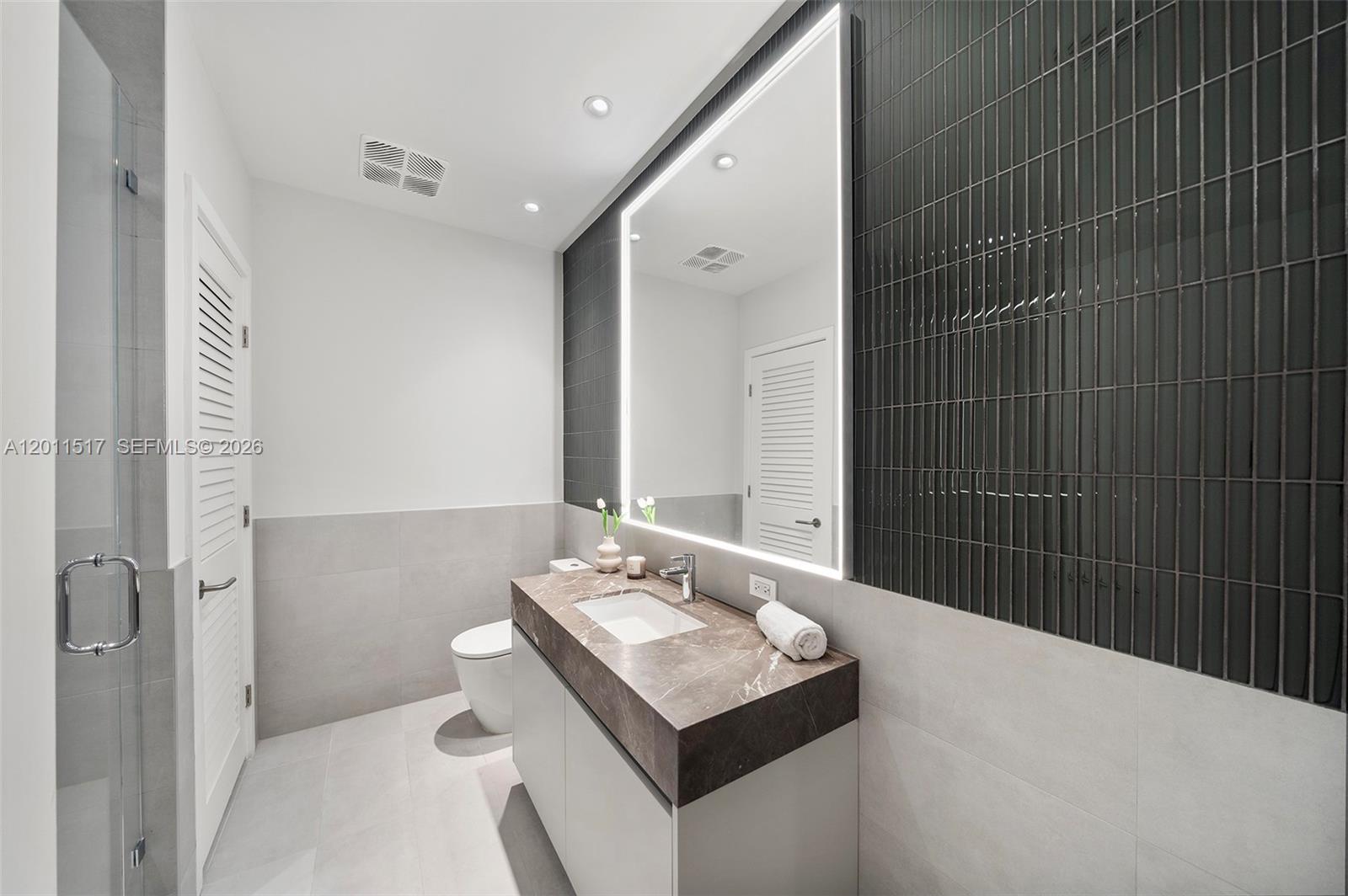 500 Alton Road, Unit 501 Miami Beach, FL 33139 - Photo 3 of 14 a bathroom with a sink a toilet and shower