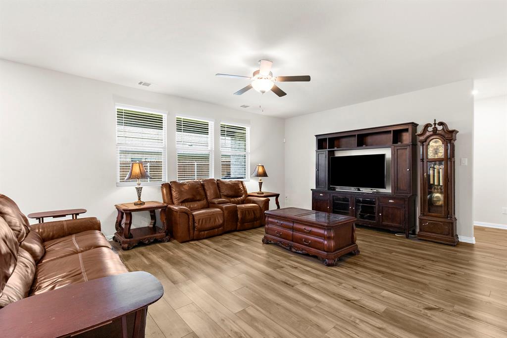 1211 Sweetleaf Street Melissa, TX 75454 - Photo 20 of 37 a living room with furniture a flat screen tv and wooden floor