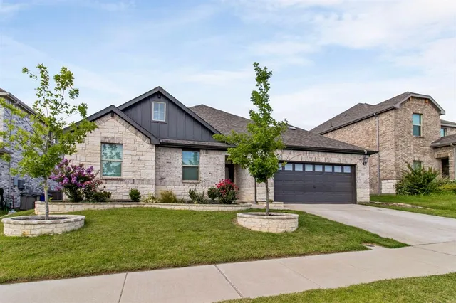 a front view of a house with a yard and potted plants
