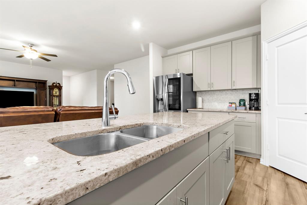 1211 Sweetleaf Street Melissa, TX 75454 - Photo 23 of 37 a kitchen with stainless steel appliances granite countertop a sink and a refrigerator