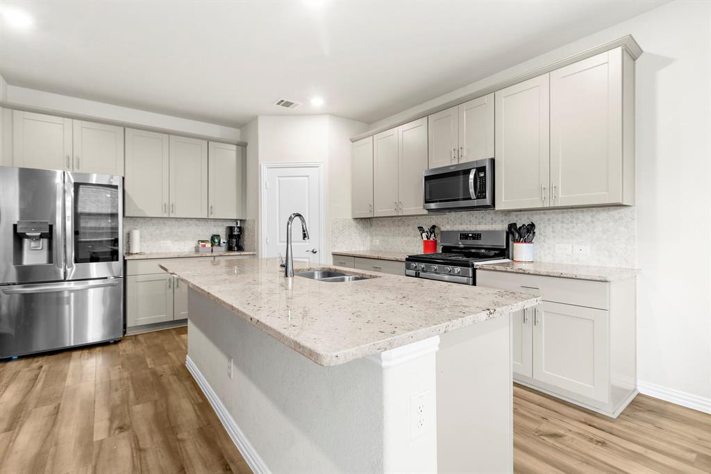 1211 Sweetleaf Street Melissa, TX 75454 - Photo 25 of 37 a kitchen with stainless steel appliances granite countertop a sink refrigerator and microwave