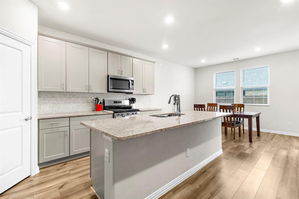 1211 Sweetleaf Street Melissa, TX 75454 - Photo 26 of 37 a kitchen with a sink stove and cabinets