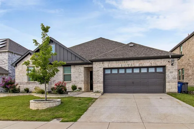 a front view of a house with a garden and garage