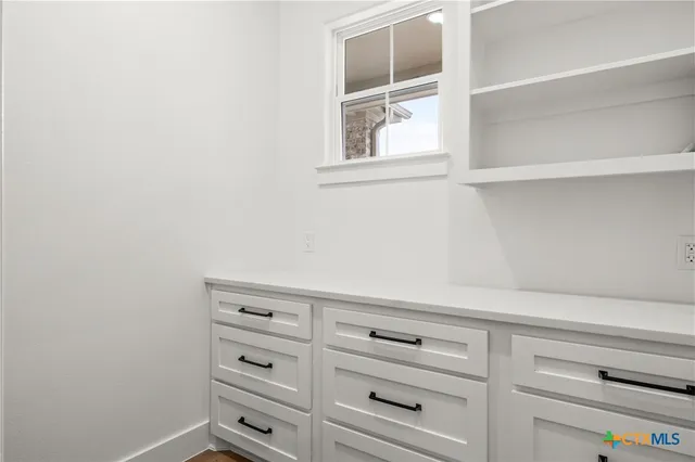 an empty room with a ceiling fan and window