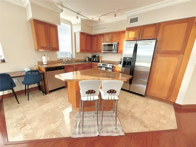 a kitchen with stainless steel appliances granite countertop sink microwave and refrigerator