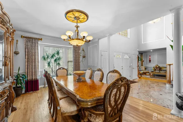 a view of a dining room with furniture a chandelier and wooden floor