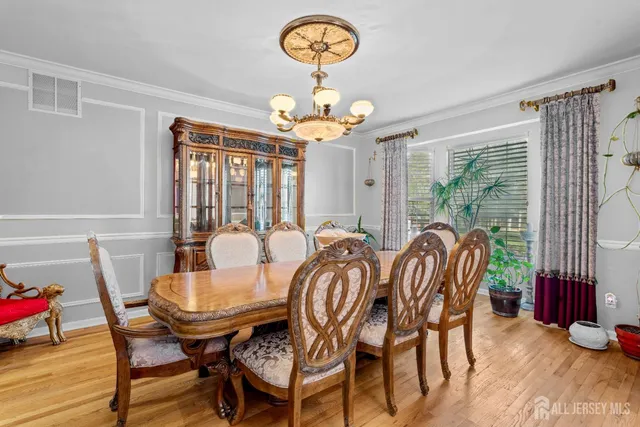 a view of a dining room with furniture wooden floor and chandelier