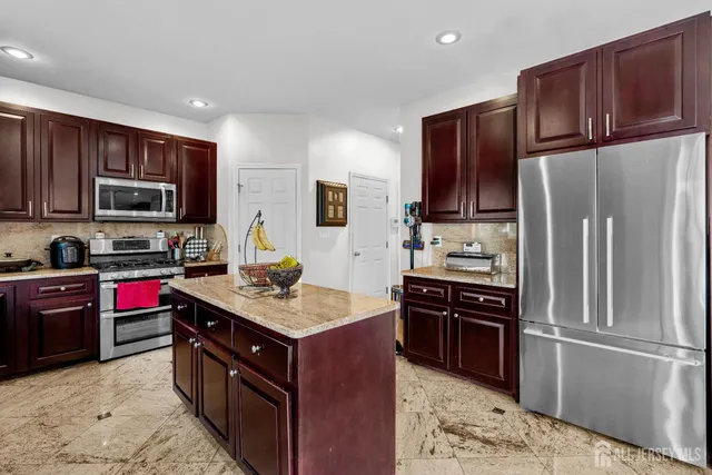 a kitchen with stainless steel appliances granite countertop a refrigerator stove and oven