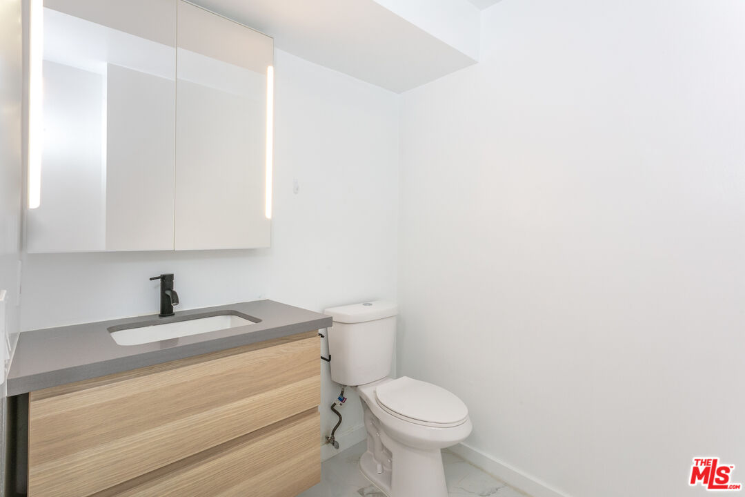 560 North Kings Road, Unit 2 West Hollywood, CA 90048 - Photo 4 of 12 a bathroom with a sink a toilet and a mirror