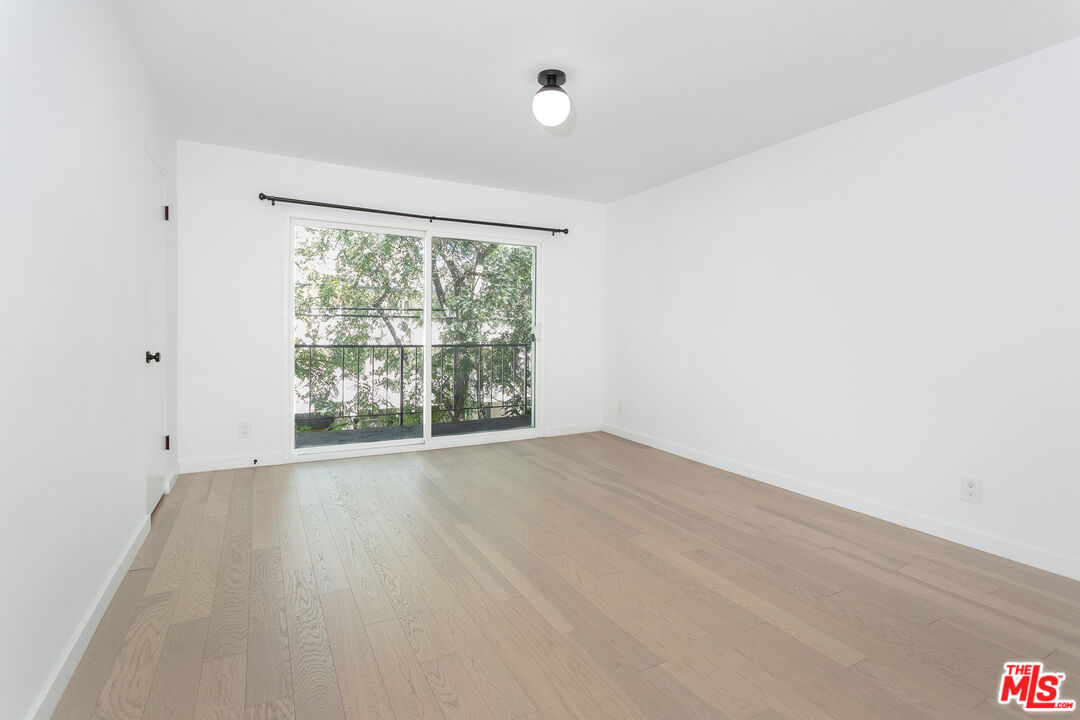 560 North Kings Road, Unit 2 West Hollywood, CA 90048 - Photo 5 of 12 an empty room with wooden floor and windows