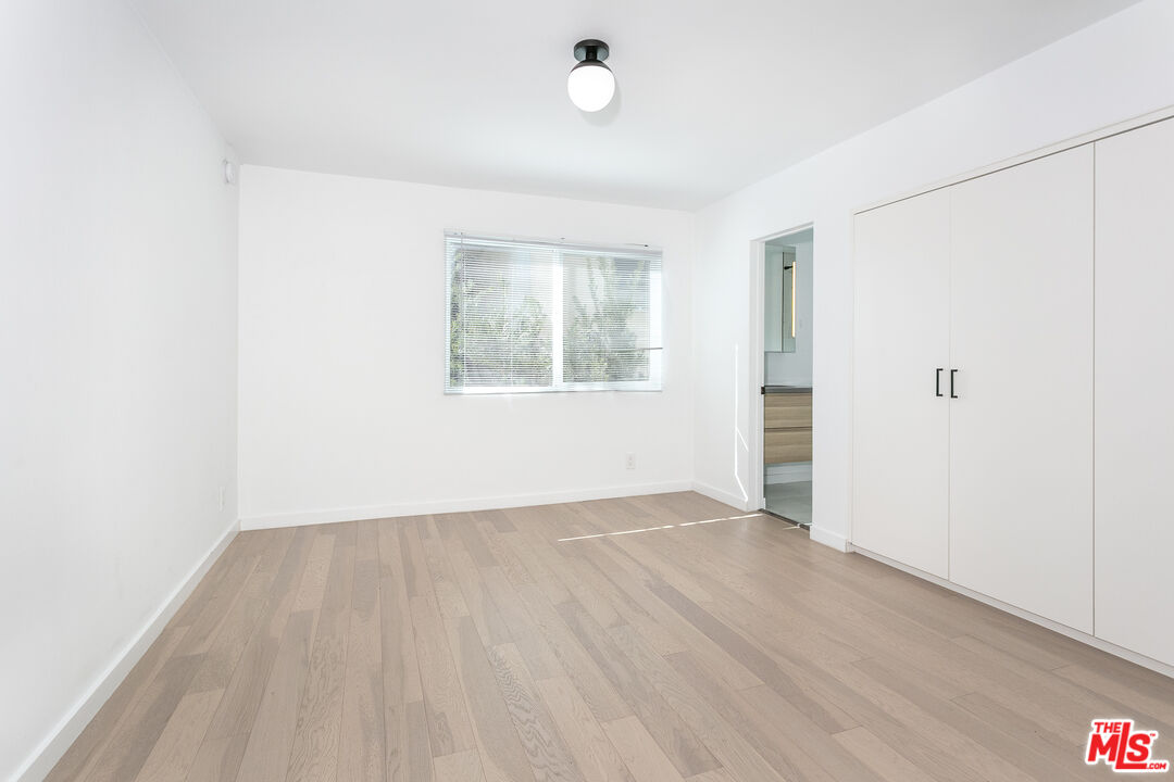 560 North Kings Road, Unit 2 West Hollywood, CA 90048 - Photo 8 of 12 an empty room with wooden floor and windows