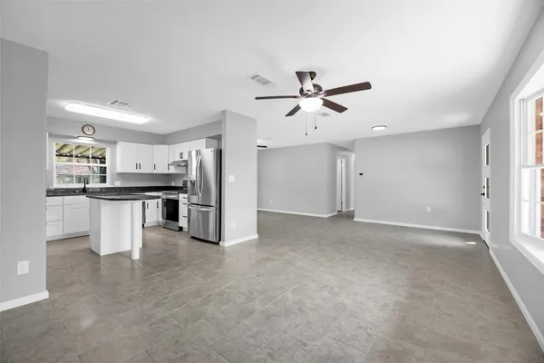 a spacious bedroom with a bed a couch and a window