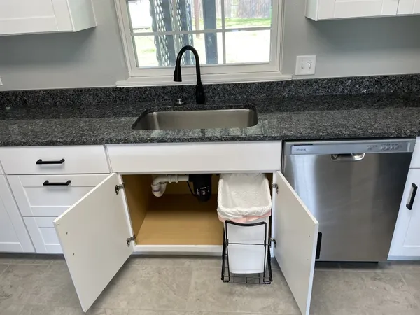 a view of a yard in front of a house with a large tree