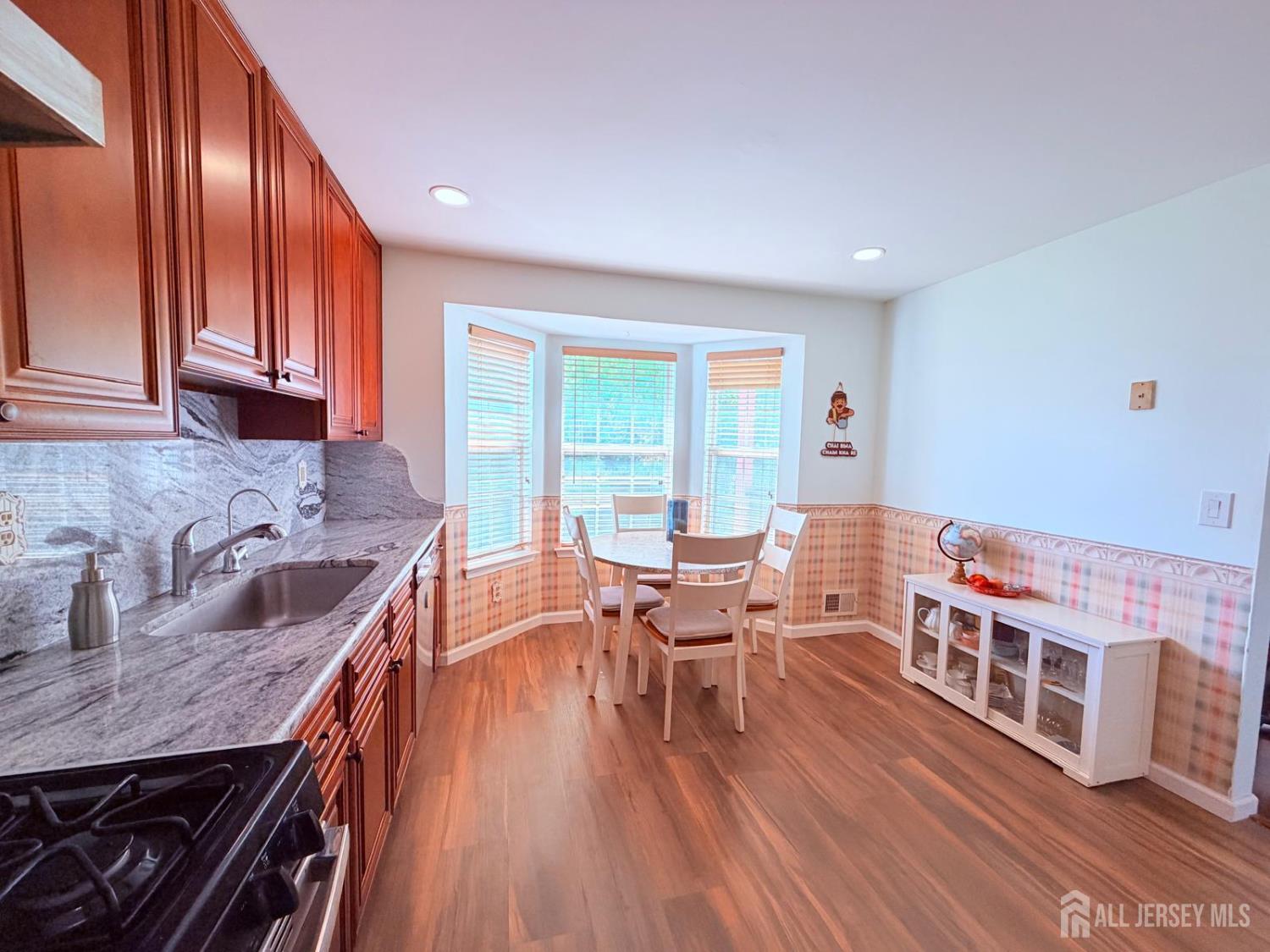 918 Plymouth Road North Brunswick, NJ 08902 - Photo 11 of 30 a kitchen with stainless steel appliances granite countertop a stove and a wooden floors