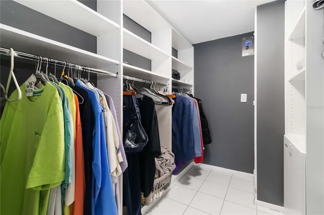 a bedroom with a bed and a large window with the view of balcony