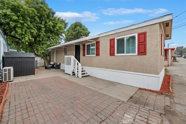 a view of house with backyard and a tree