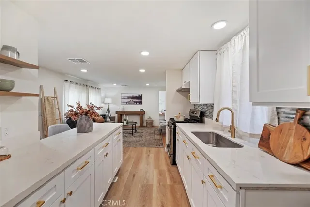 a large kitchen with stainless steel appliances lots of counter space and a sink