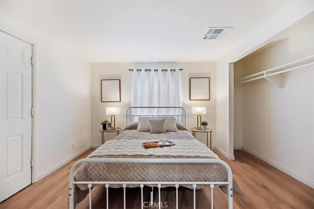 a bedroom with a bed and wooden floor