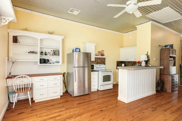 a kitchen with white cabinets and refrigerator