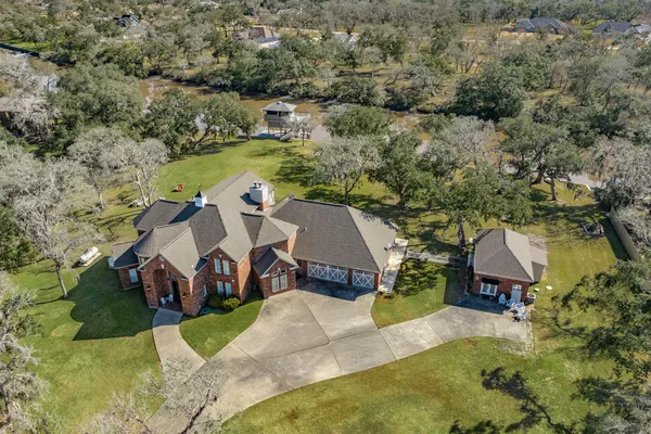 an aerial view of a house with a yard and lake view