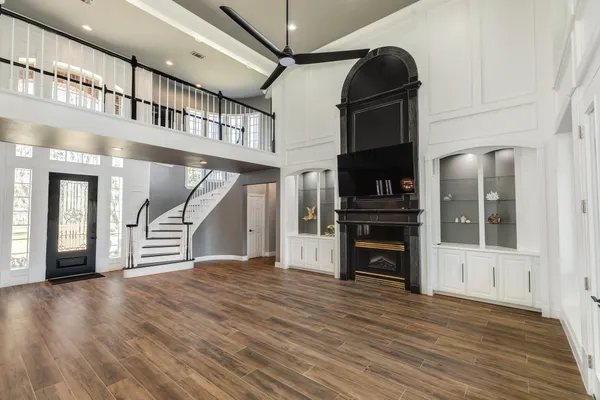 an empty room with wooden floor and a fireplace