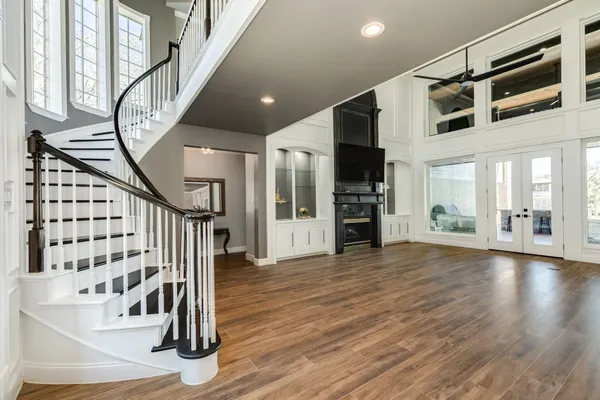 a view of an entryway with wooden floor windows and a kitchen view