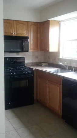 a kitchen with granite countertop a stove a sink and a microwave