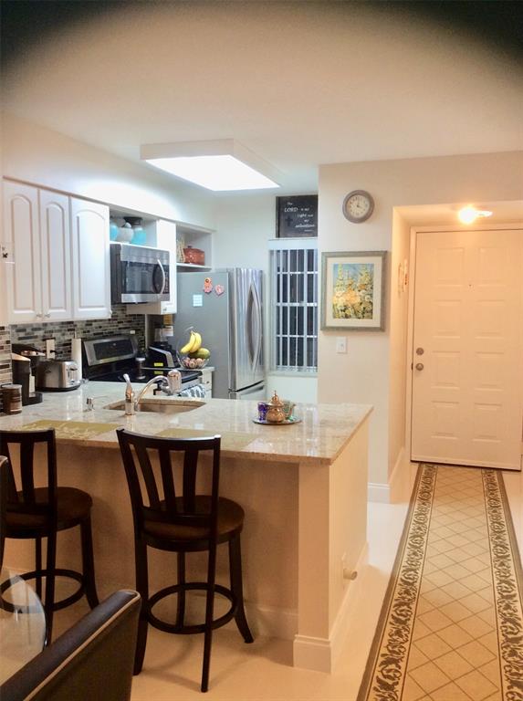 Undisclosed Address Pompano Beach, FL 33069 - Photo 11 of 23 a kitchen with stainless steel appliances granite countertop a stove and a refrigerator