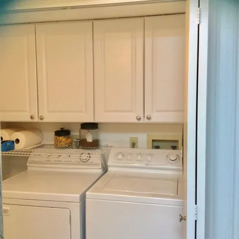 a view of washer and dryer with kitchen in the background