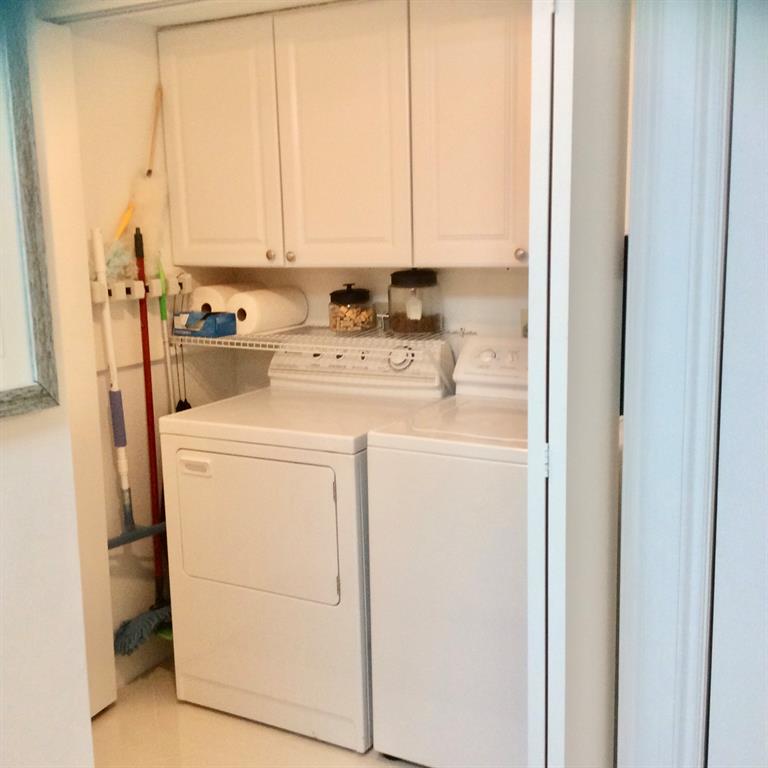 Undisclosed Address Pompano Beach, FL 33069 - Photo 23 of 23 a view of washer and dryer with kitchen in the background