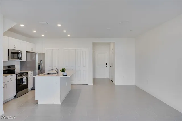 a kitchen with stainless steel appliances a refrigerator and a stove top oven