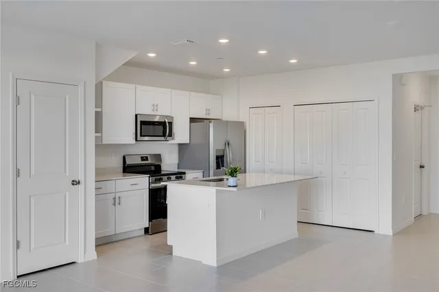 a kitchen with white cabinets and stainless steel appliances