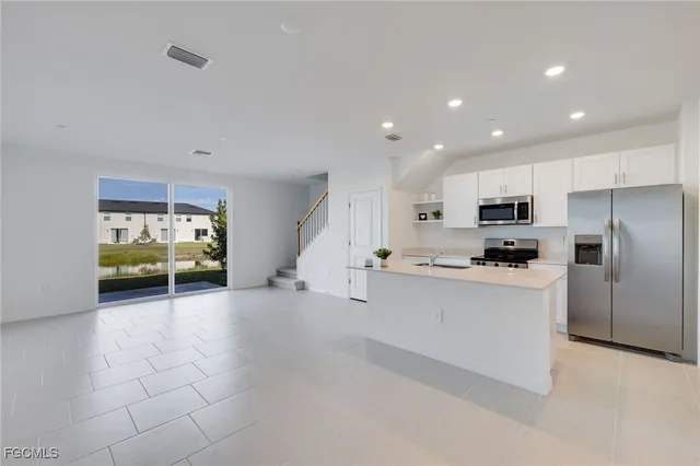a kitchen with stainless steel appliances a refrigerator sink and microwave